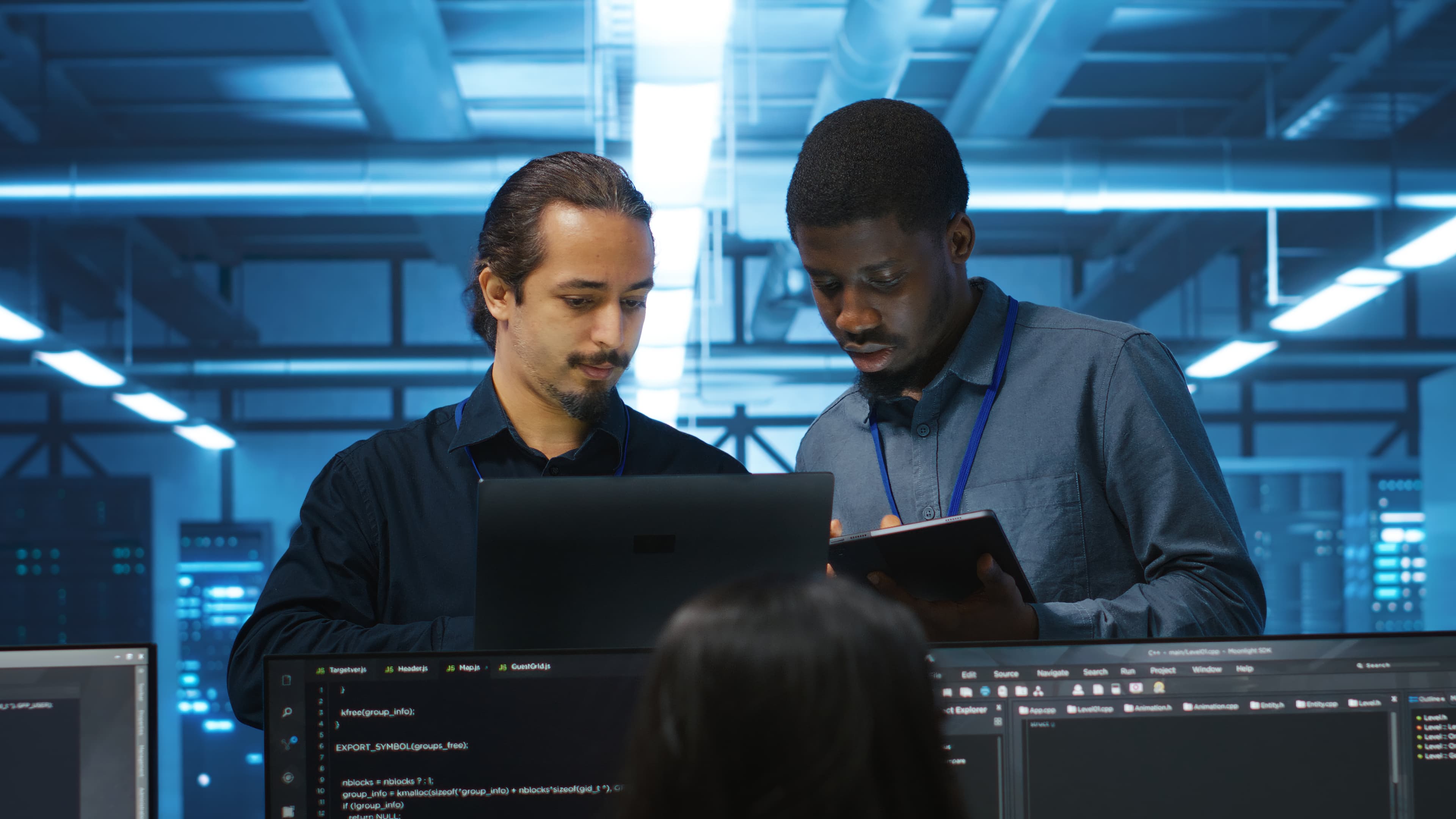 Two cybersecurity experts collaborating in front of a laptop