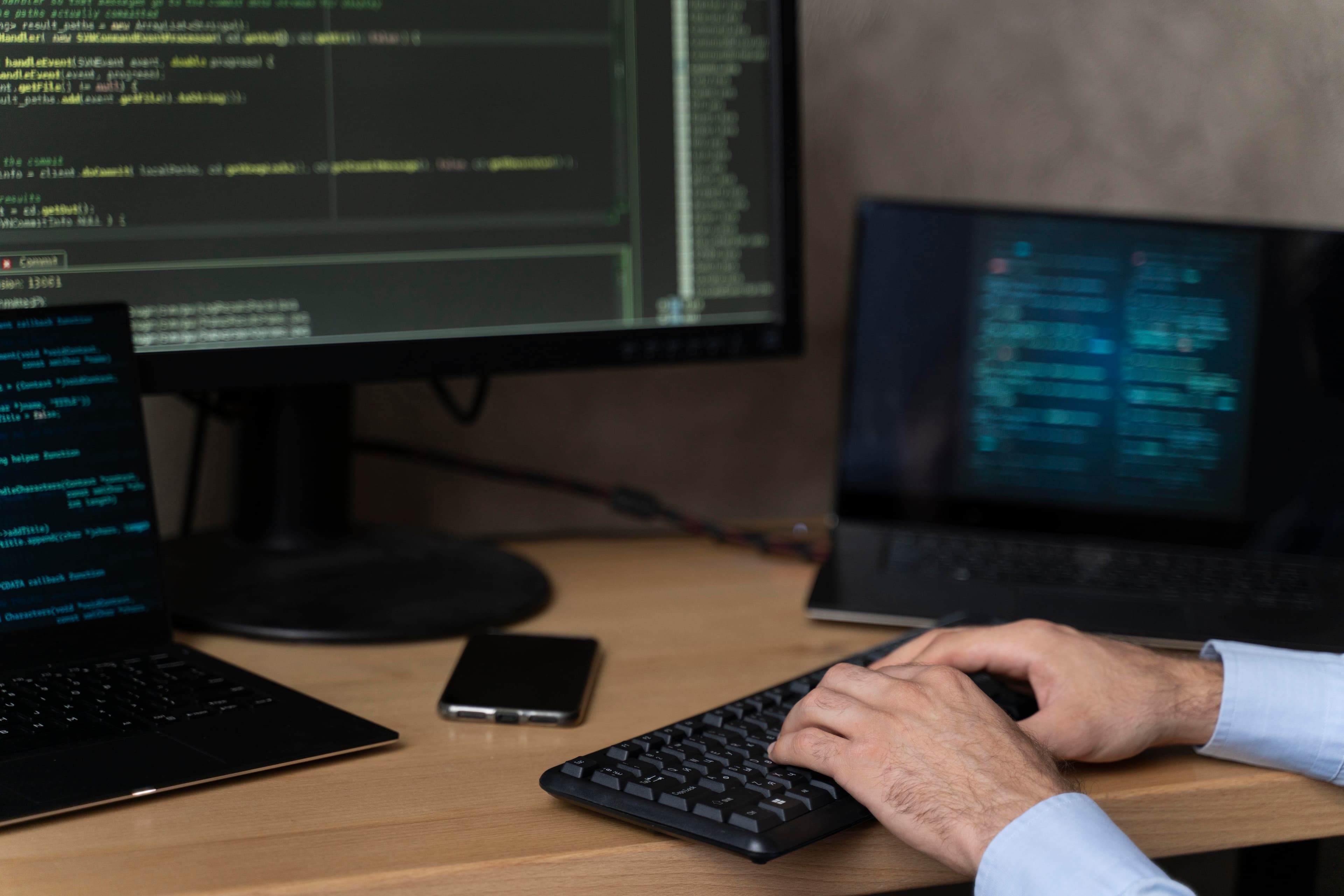 Developer working on multiple screens displaying code